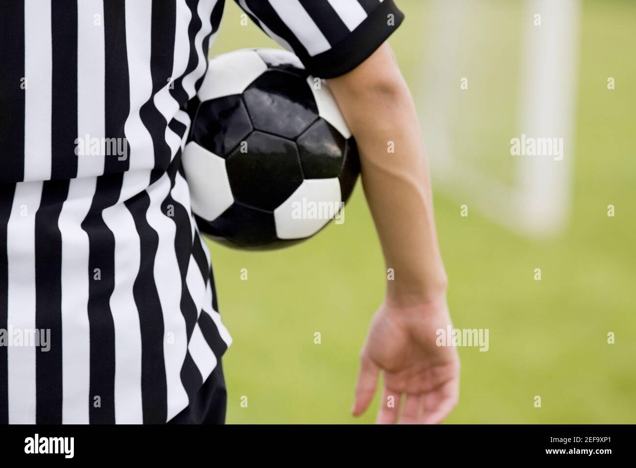 Mittelansicht eines Schiedsrichters mit einem Fußball Unter seinem Arm Stockfoto