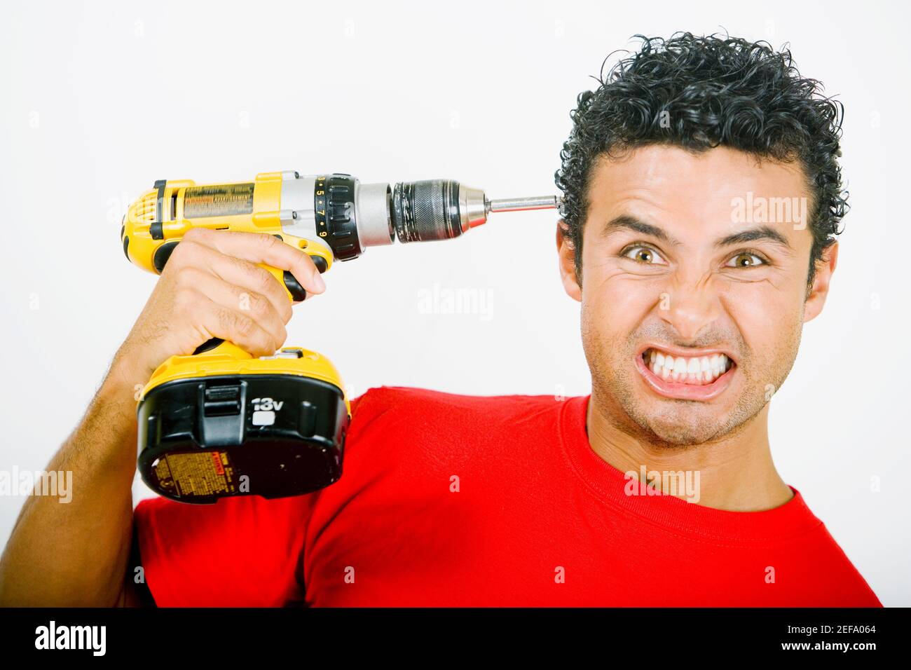 Porträt eines jungen Mannes, der eine Bohrmaschine anhält Seinen Kopf Stockfoto