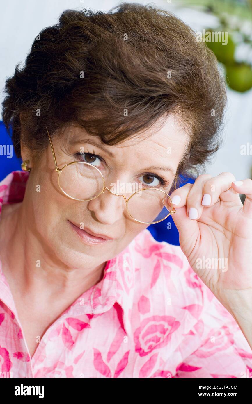 Porträt einer älteren Frau, die über ihre Brille guckt Stockfoto