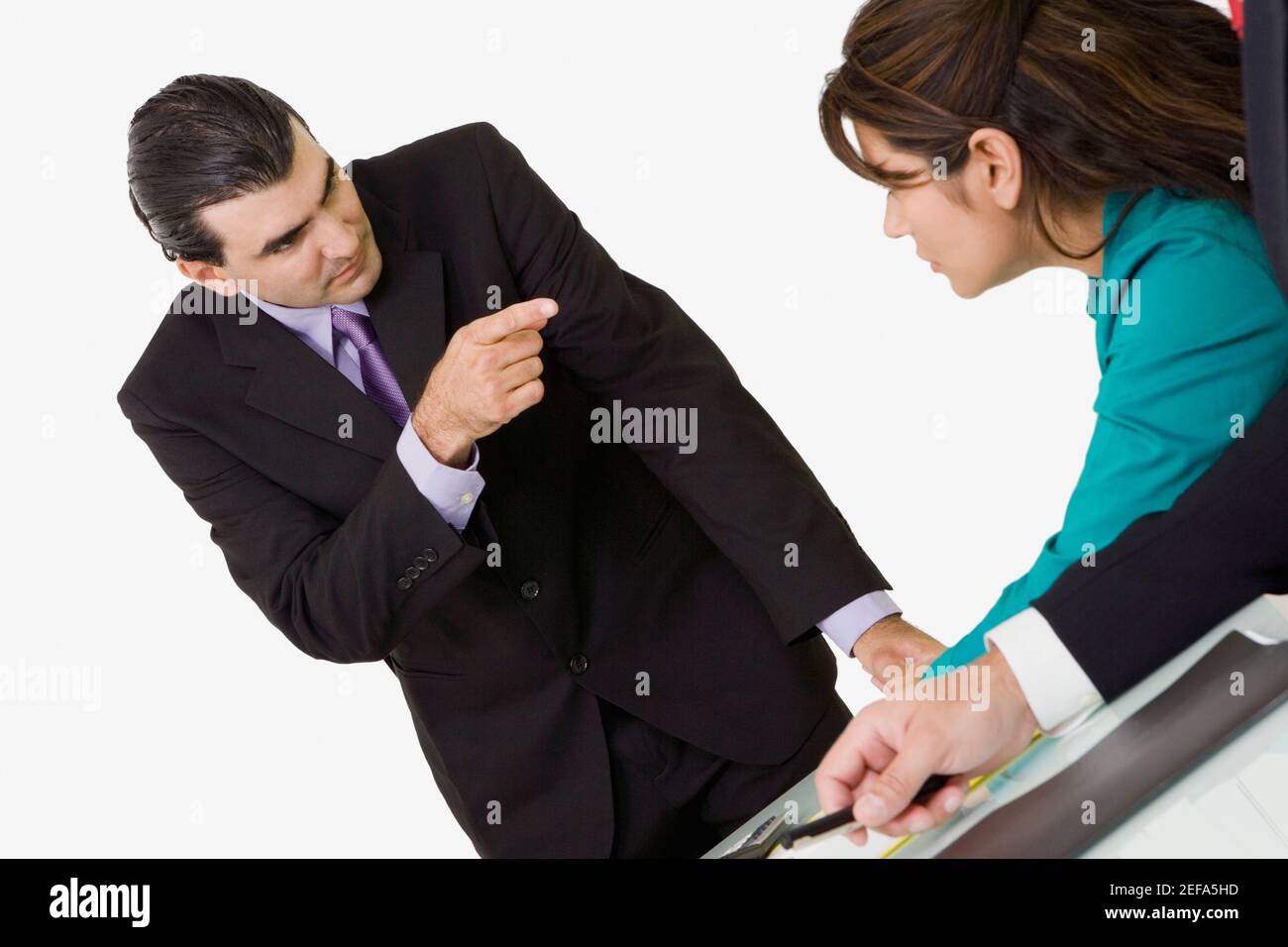 Geschäftsmann zeigt auf eine Geschäftsfrau, die vor ihm sitzt Stockfoto