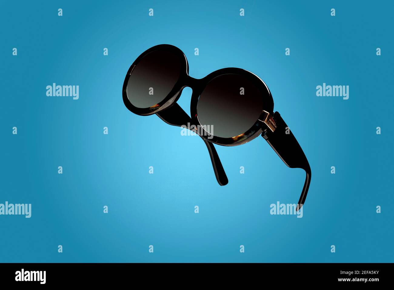 Weibliche Damen Sonnenbrille auf blauem Hintergrund mit Kopierraum Und Platz für Text Stockfoto