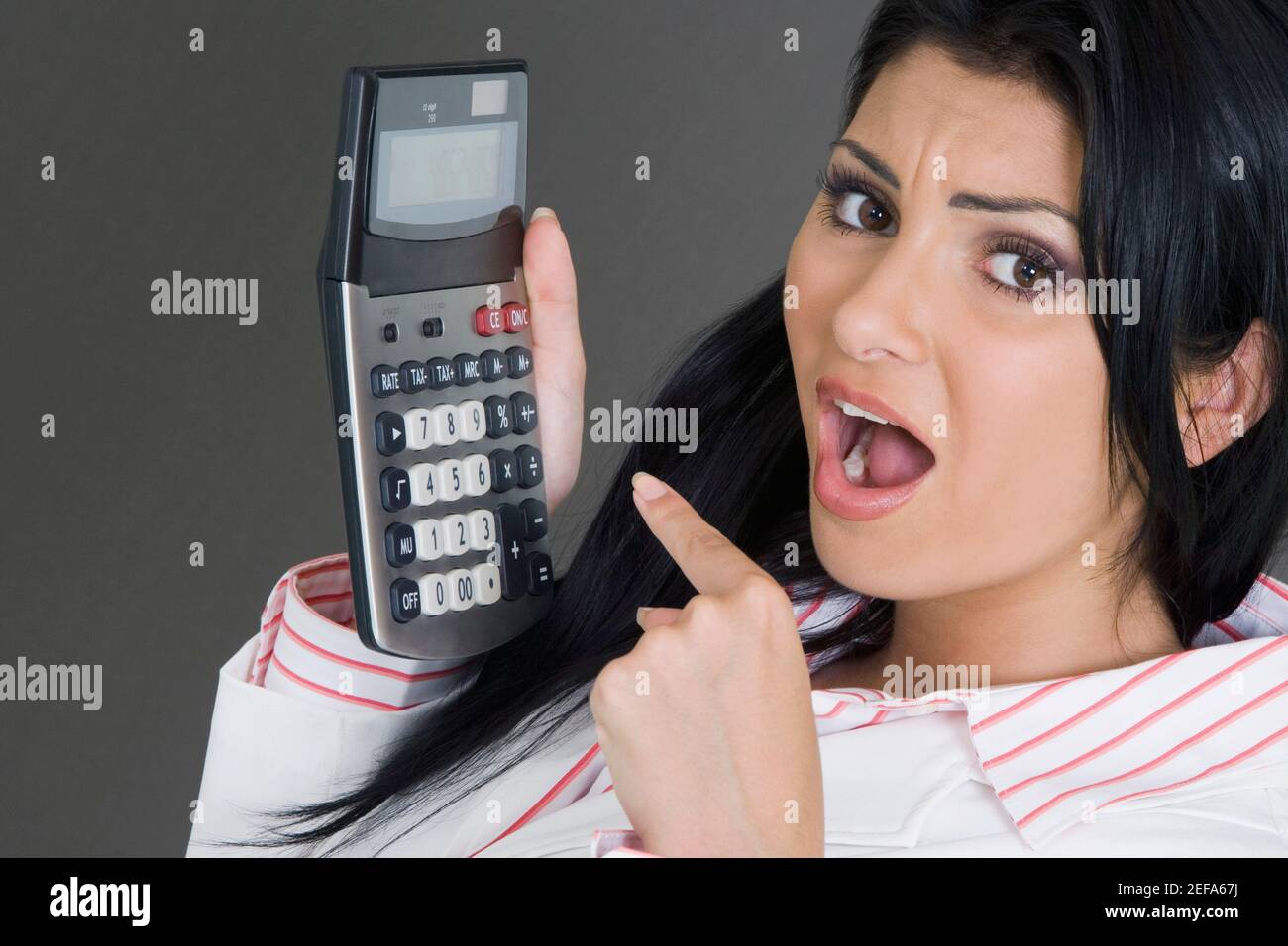 Porträt einer Geschäftsfrau, die auf einen Rechner zeigt Stockfoto