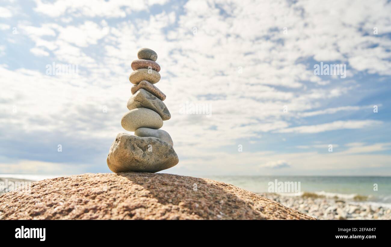 Hoher Steinstapel im Gleichgewicht als Zen und buddhismus Konzept am Strand Stockfoto