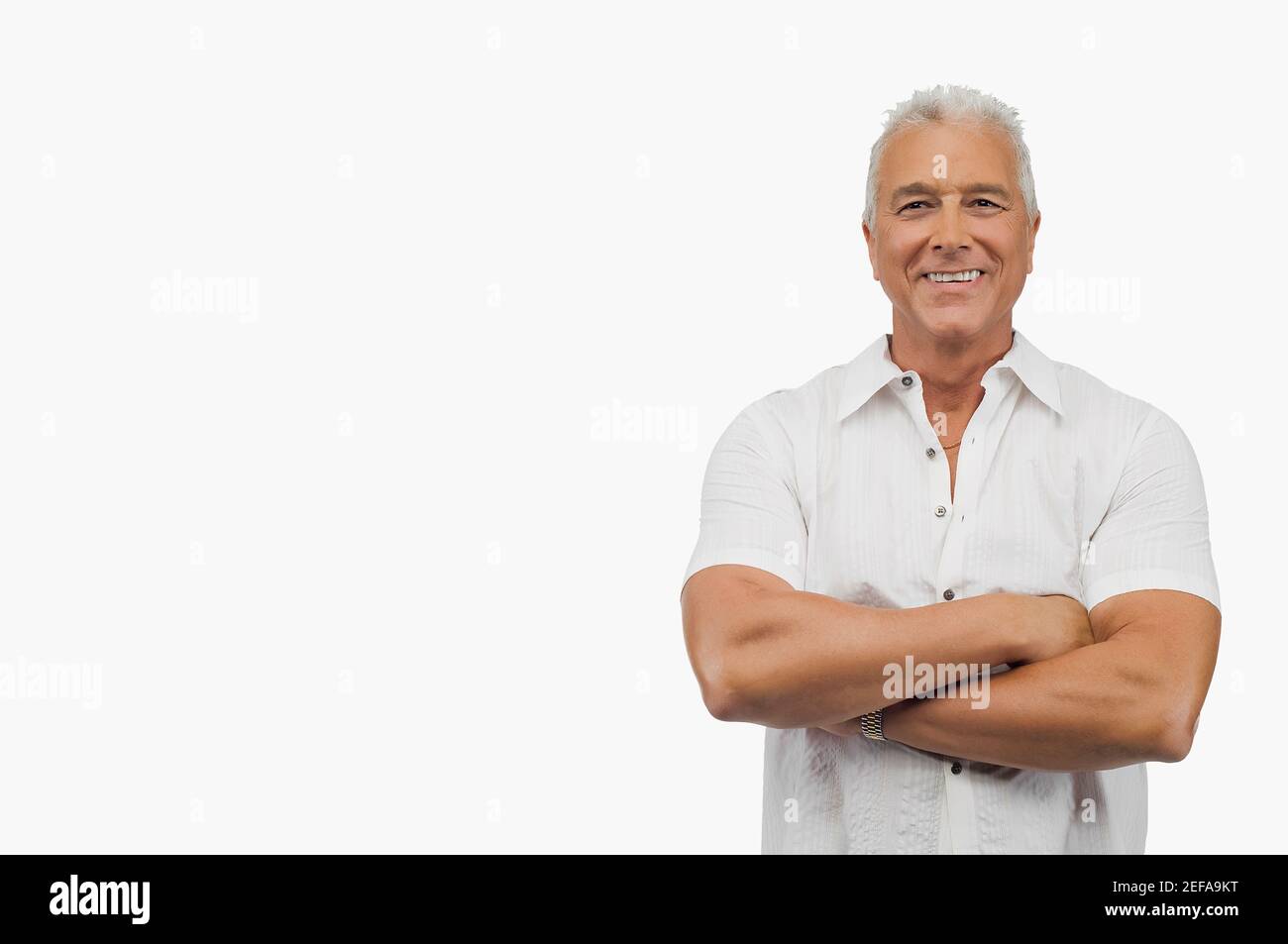 Porträt eines älteren Mannes, der mit gekreuzten Armen steht Und lächelnd Stockfoto