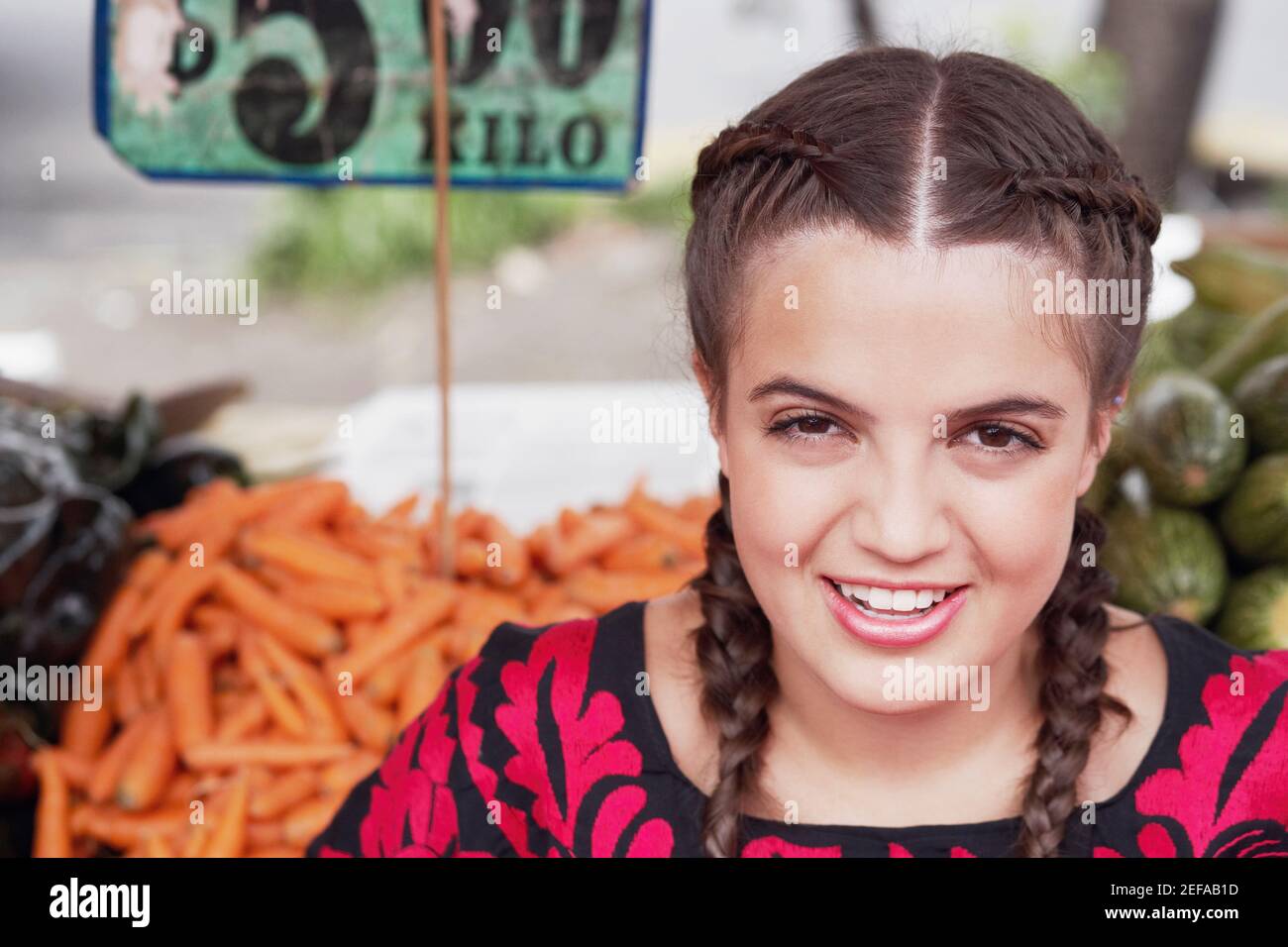 Porträt einer jungen Frau, die an einem Marktstand lächelt Stockfoto