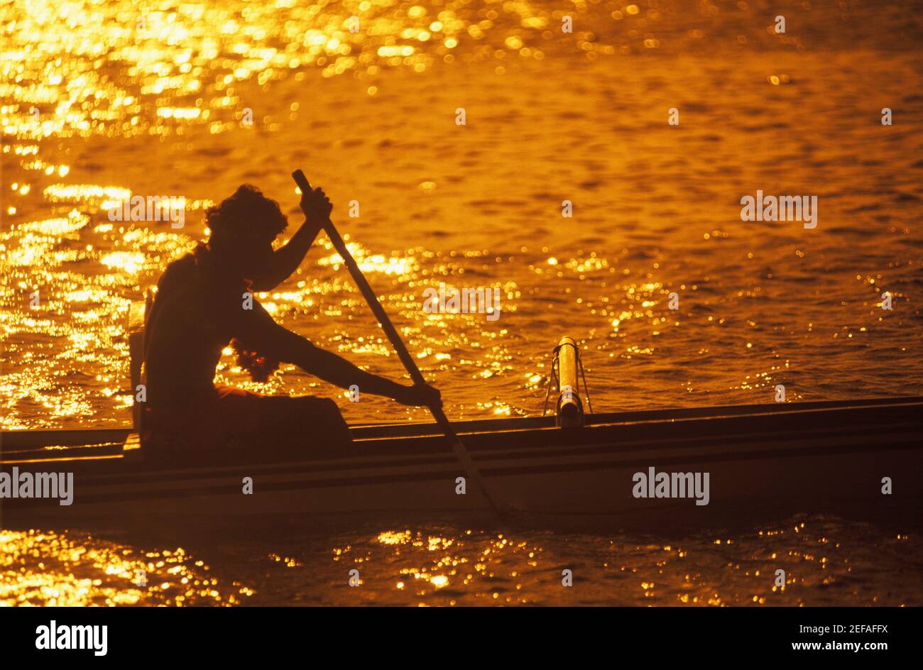Silhouette einer Person, die in der Abenddämmerung ein Boot rudert, Hawaii, USA Stockfoto