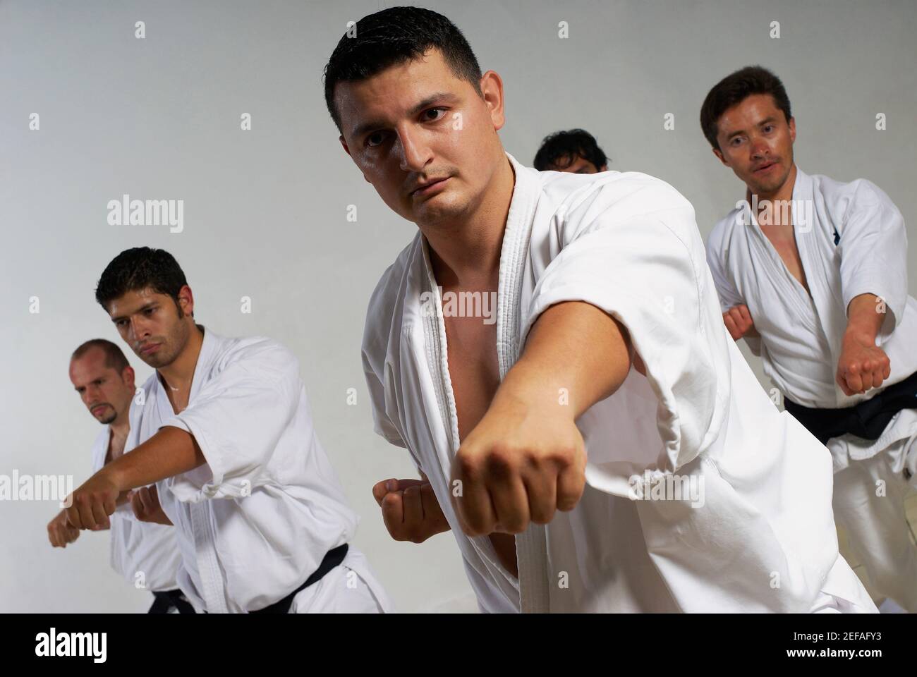 Drei Männer mittleren Erwachsenen mit einem jungen Mann, der Karate praktiziert Stockfoto