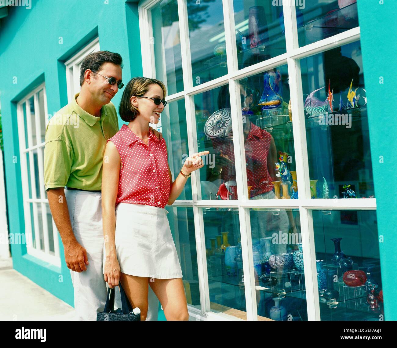 Junges Paar, das vor einem Schaufenster steht und auf die dekorative Urne Bermuda schaut Stockfoto