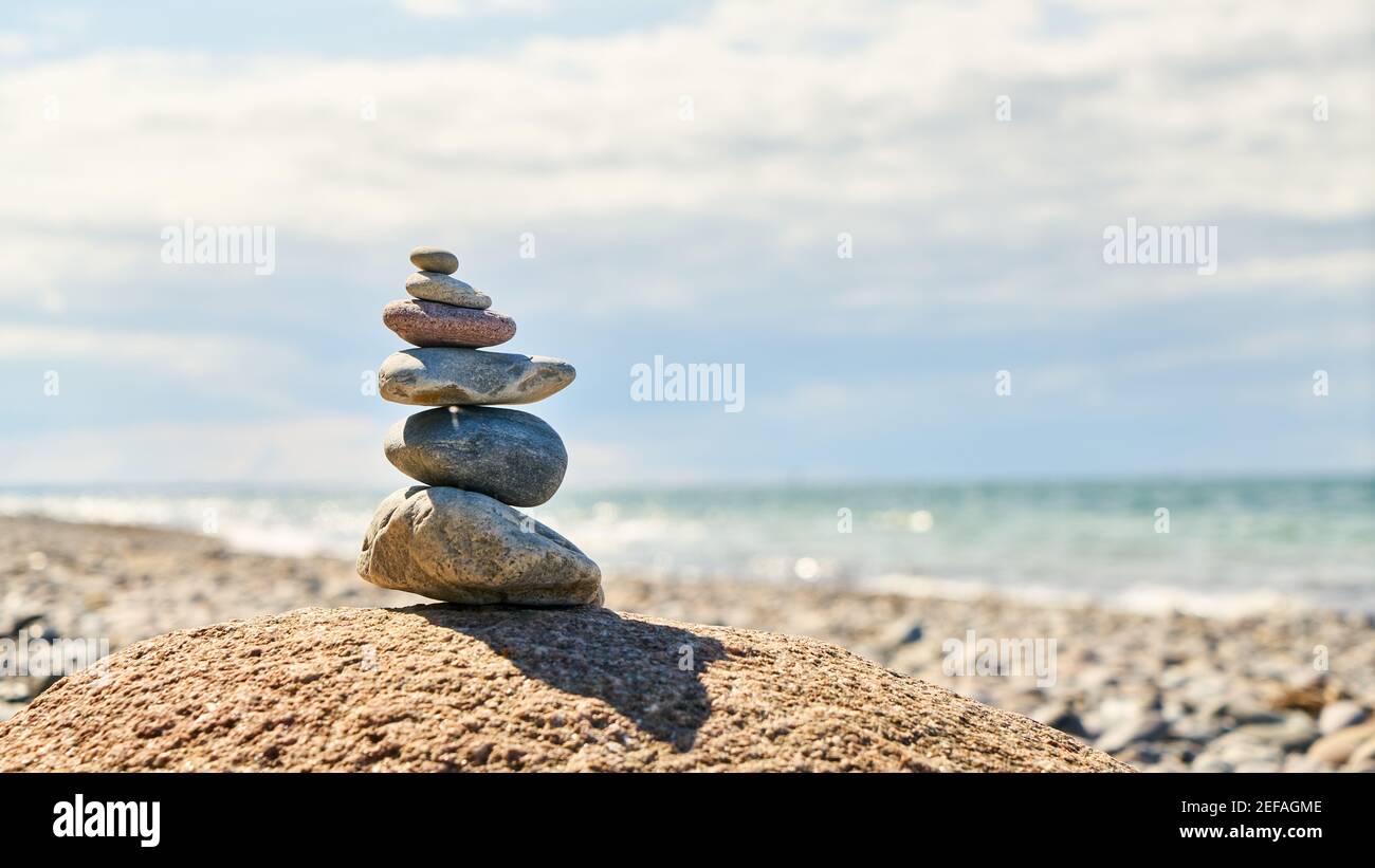 Steinstapel für Zen Entspannung und Meditation auf dem Strand am Meer im Sommer Stockfoto