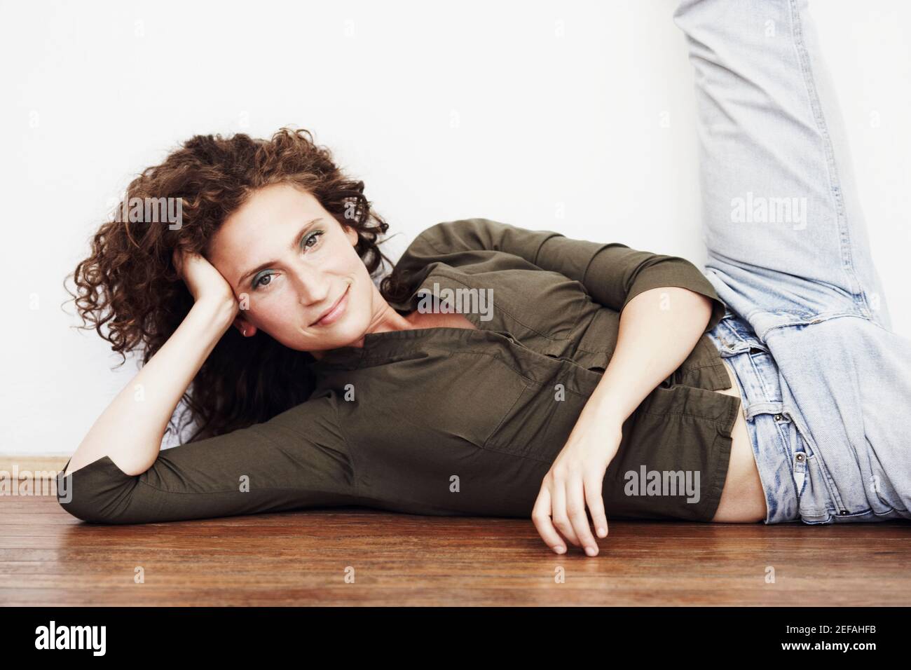 Porträt einer mittleren erwachsenen Frau, die auf dem Boden liegt Stockfoto