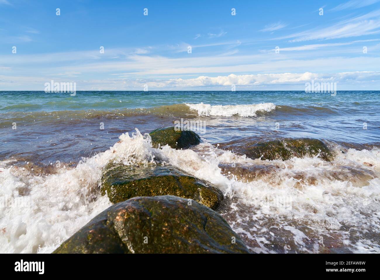 Wellen brechen mit Spray auf Felsen vom Ufer vorbei Das Meer Stockfoto