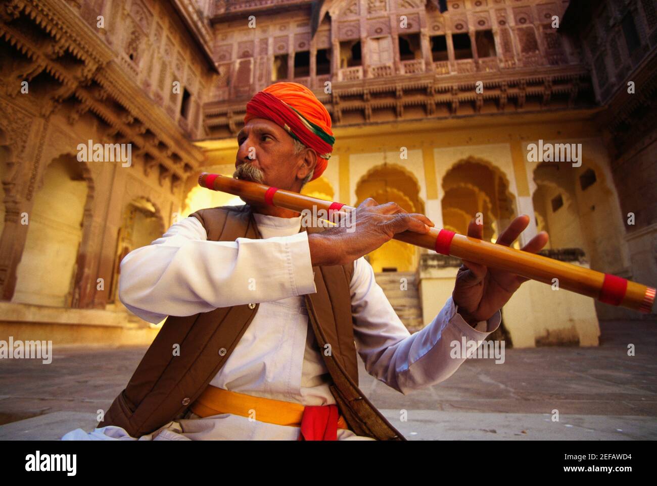 Nahaufnahme eines reifen Mannes, der eine Flöte in einem Fort spielt, Meherangarh Fort, Jodhpur, Rajasthan, Indien Stockfoto