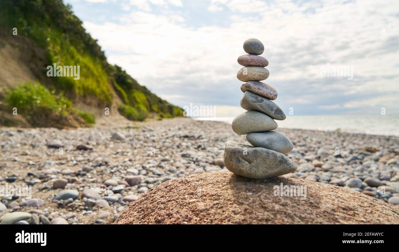 Stapel von Steinen im Gleichgewicht als Zen-Meditation Konzept auf Der Strand am Meer Stockfoto