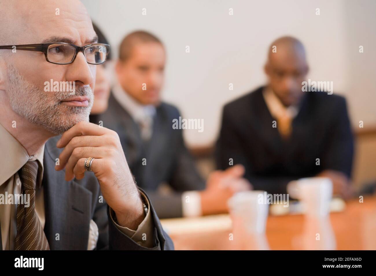 Nahaufnahme eines Geschäftsmannes mit seinen Kollegen im Hintergrund Stockfoto