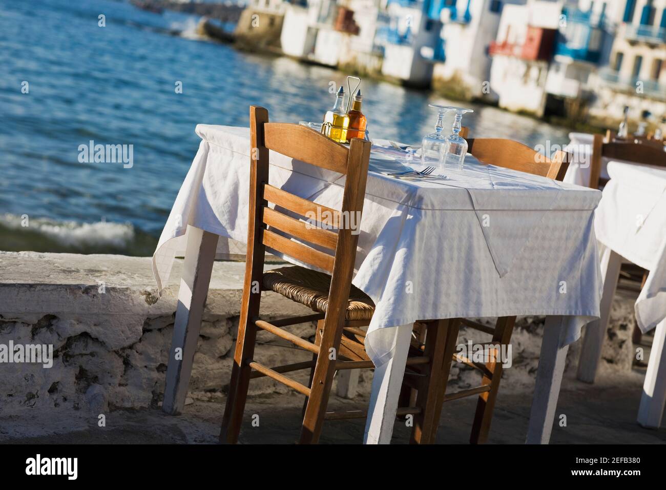 Tisch und Stühle in Küstennähe, Mykonos, Kykladen, Griechenland Stockfoto