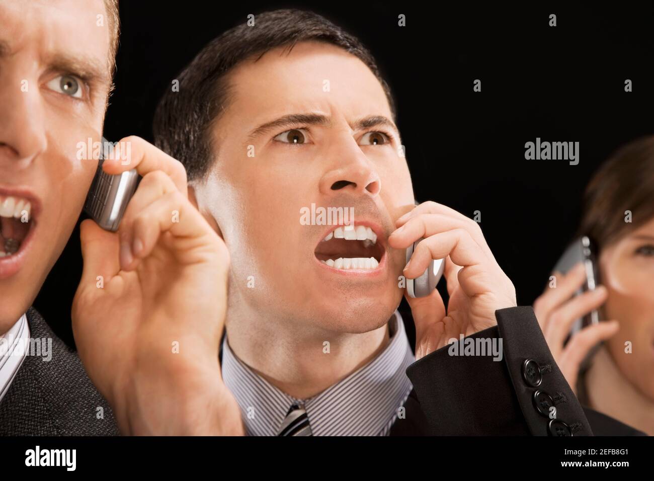 Nahaufnahme von Geschäftsführern, die auf Mobiltelefonen schreien Stockfoto