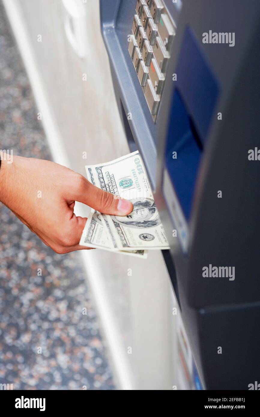 Nahaufnahme einer personÅ½s Hand, die hundert Dollarscheine erhält Von einem Geldautomaten Stockfoto