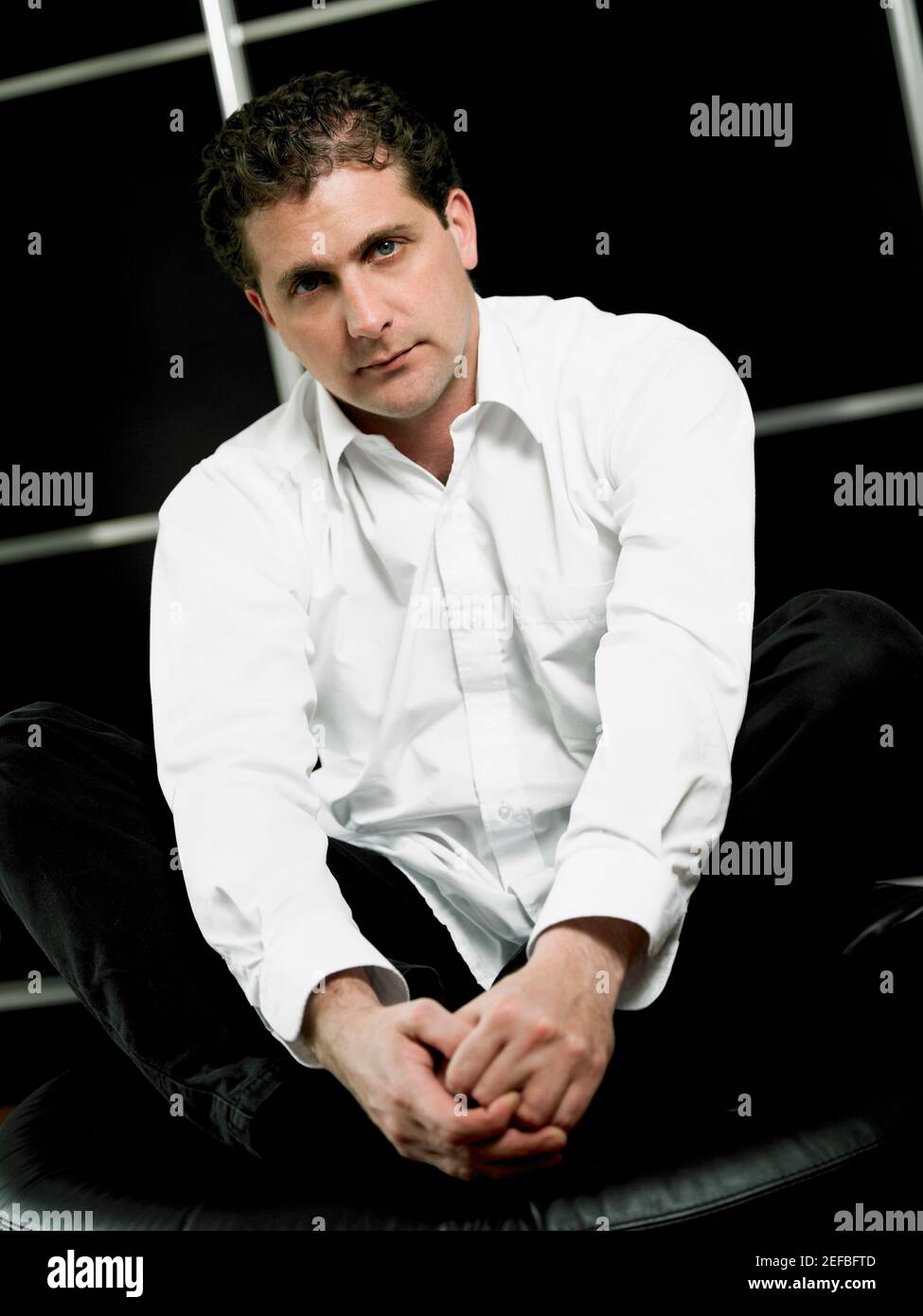 Porträt eines mittleren Erwachsenen Mann sitzt und hält seine Fuß Stockfoto