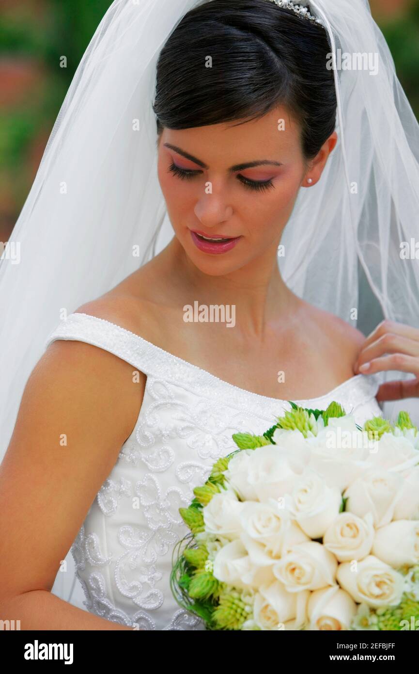 Nahaufnahme einer Braut mit einem Blumenstrauß und Blick nach unten Stockfoto