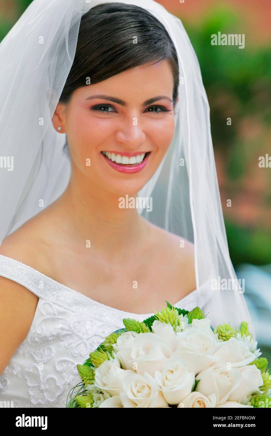 Porträt einer Braut hält einen Blumenstrauß und lächelnd Stockfoto