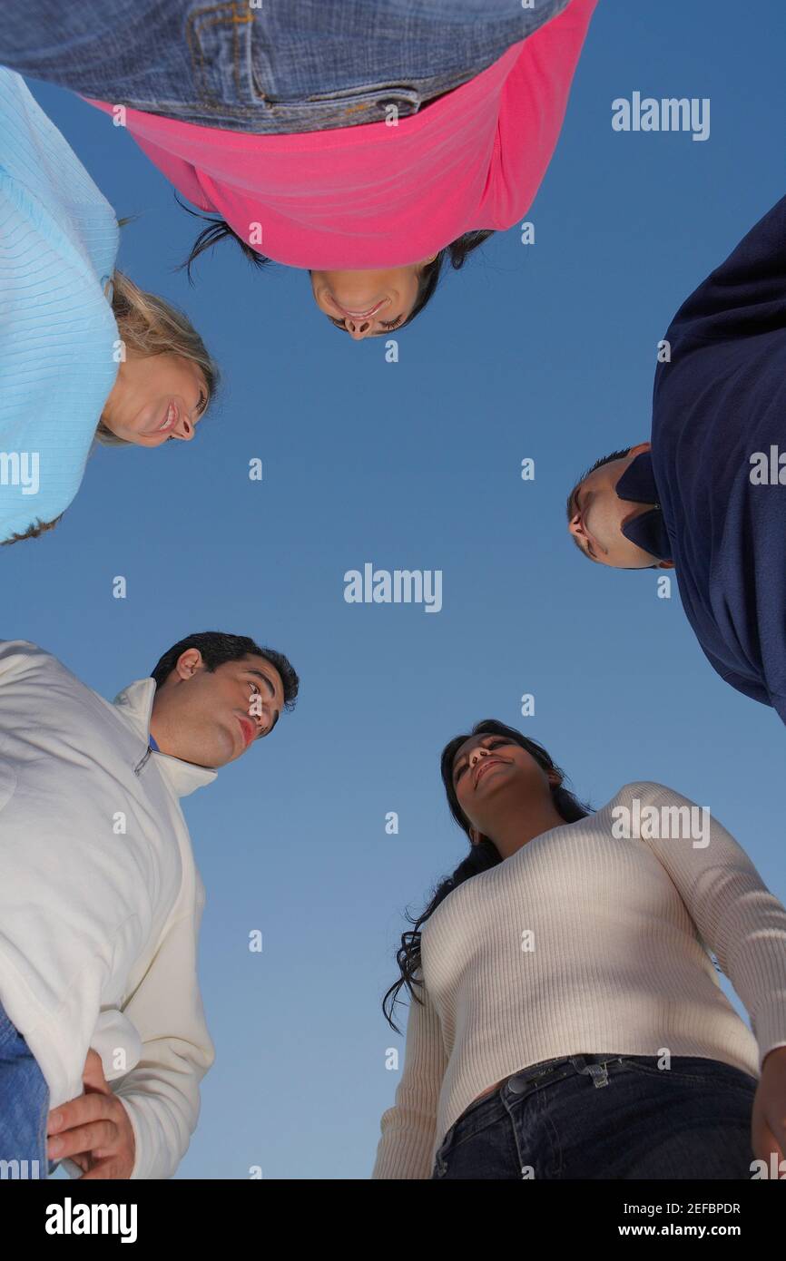 Low-Angle-Ansicht von zwei mittleren Erwachsenen Männer und ein Mittlere Erwachsene Frau mit zwei jungen Frauen, die Gesicht zu stehen Gesicht Stockfoto