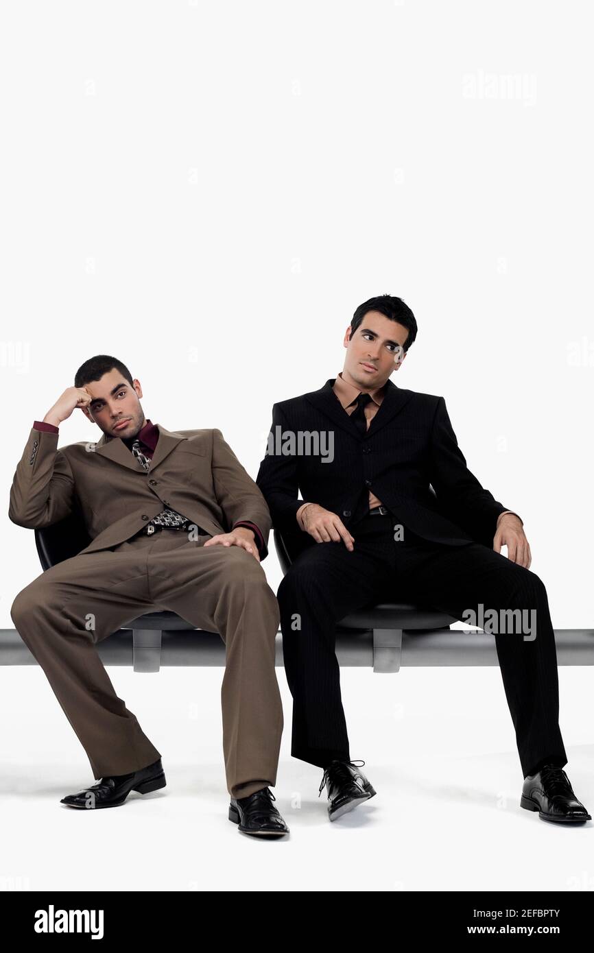 Zwei Geschäftsleute, die auf einer Bank sitzen und gestresst aussehen Stockfoto
