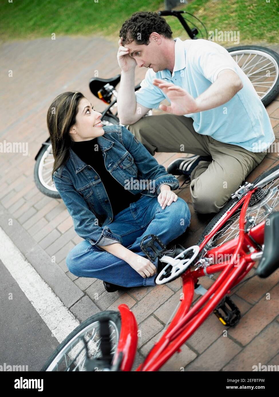Blick auf ein mittelerwachsenes Paar, mit dem man sitzt Fahrräder und einander anschauen Stockfoto