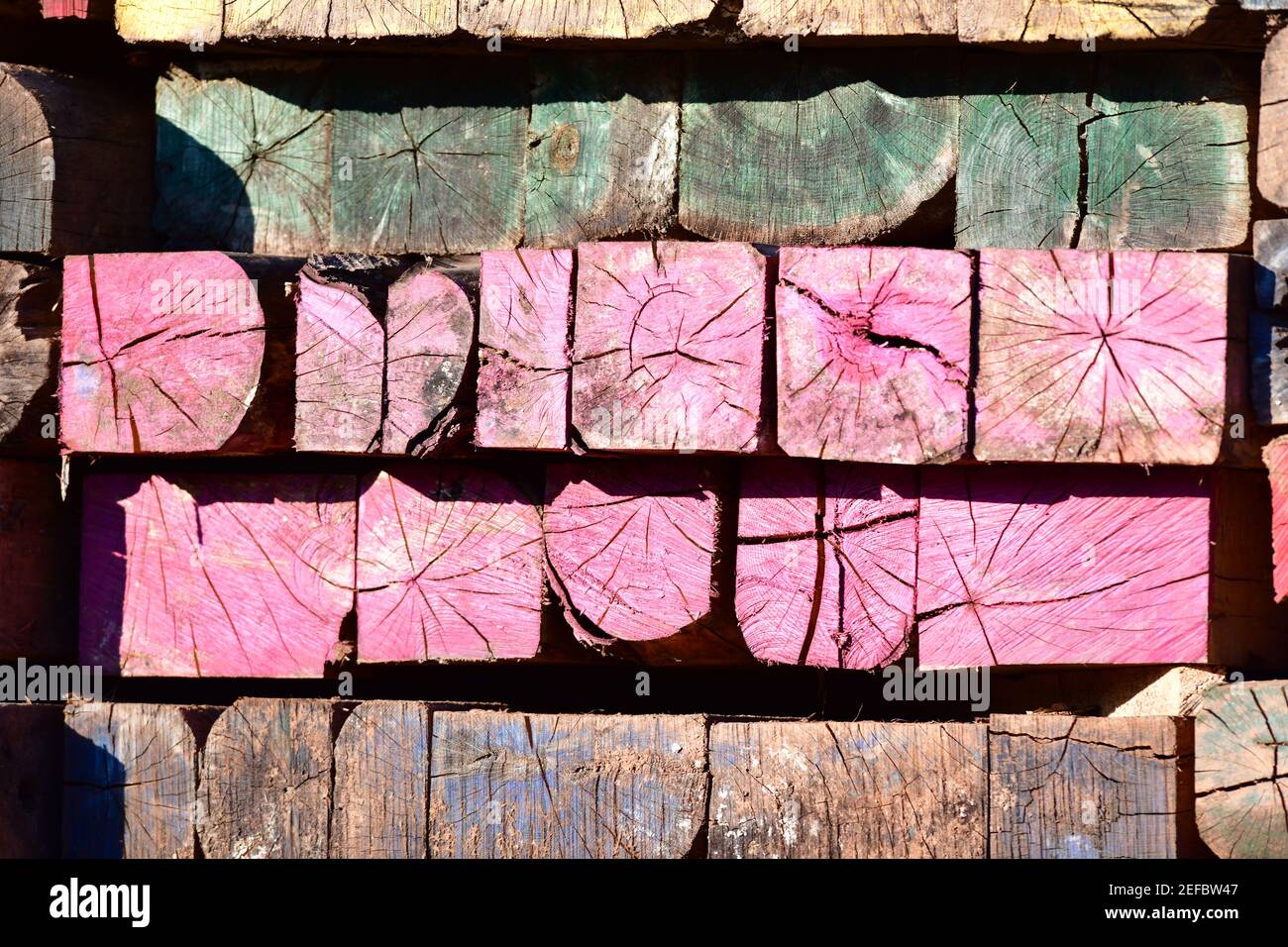 Lebendige Mehrfarbige Holz Mosaik Lackiert Gealterte Verwitterte Industrie Balken. Stockfoto