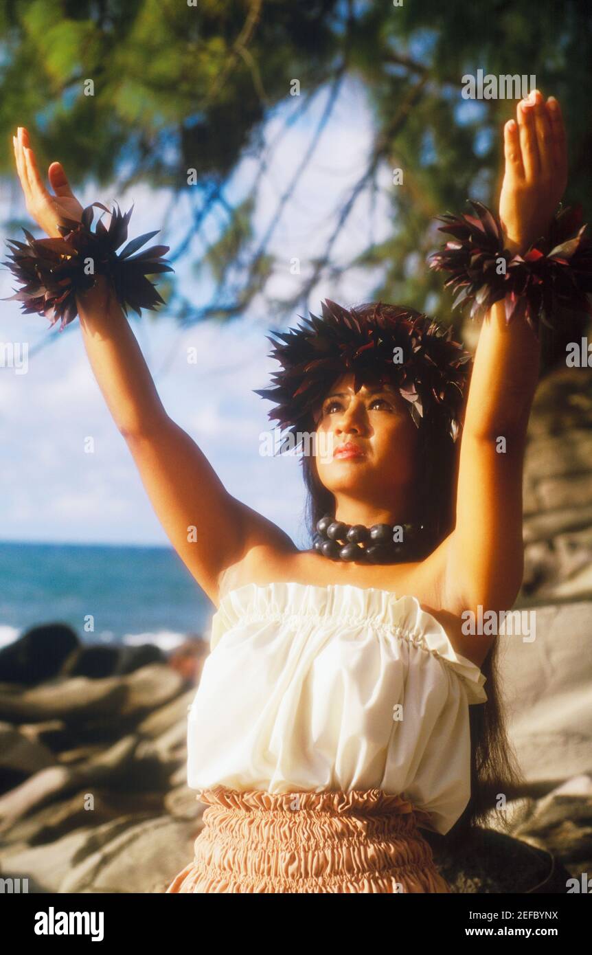 Nahaufnahme einer Hula-Tänzerin, die am Strand mit erhobenen Armen steht, Hawaii, USA Stockfoto