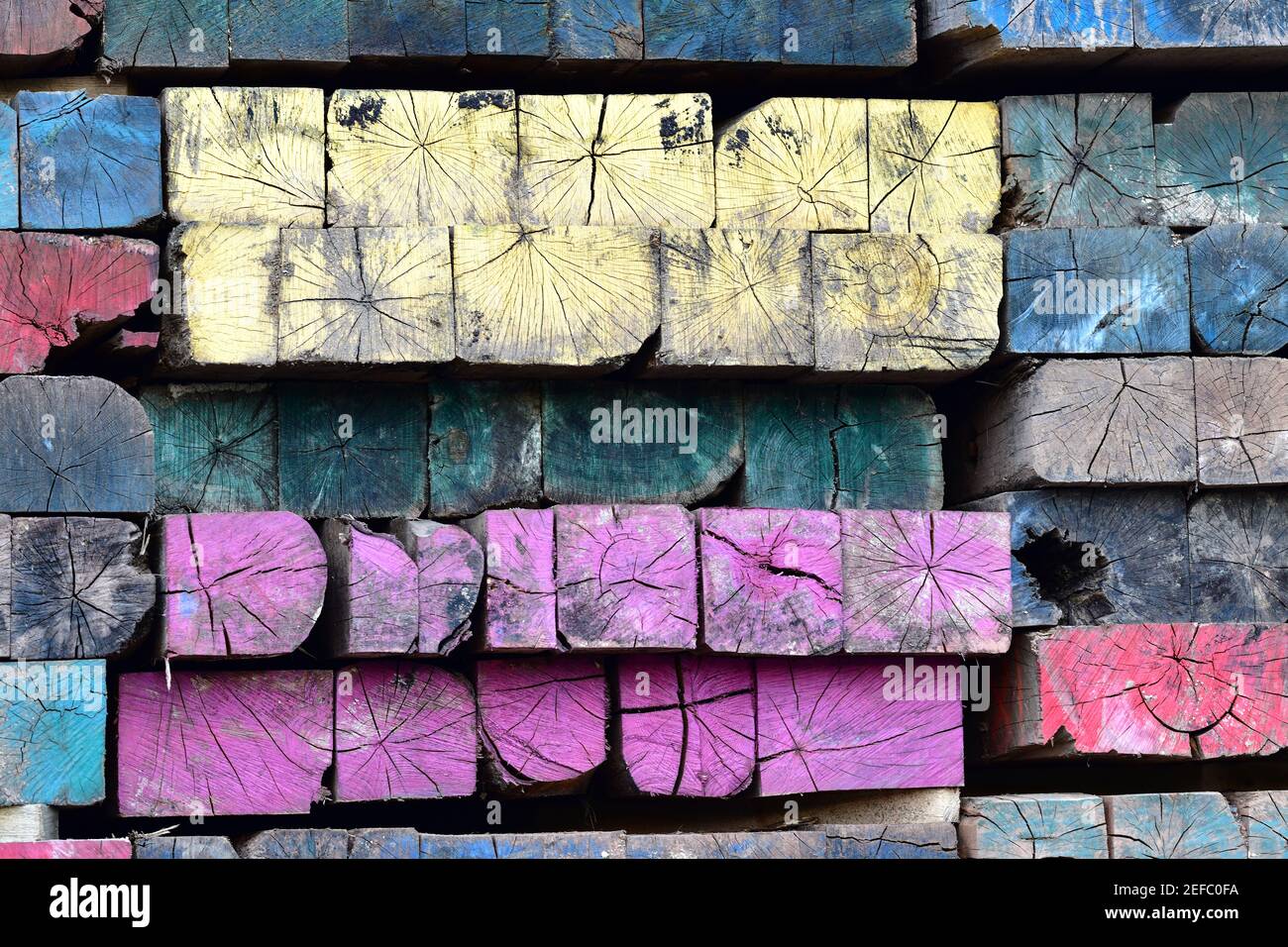 Lebendige Mehrfarbige Holz Mosaik Lackiert Gealterte Verwitterte Industrie Balken. Stockfoto