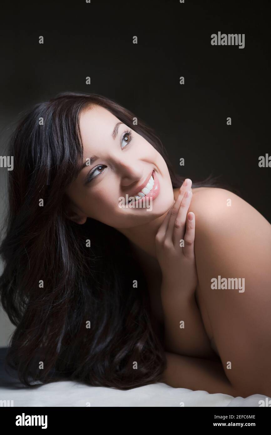 Nahaufnahme einer jungen Frau, die auf einem Massageliegen liegt Und lächelnd Stockfoto