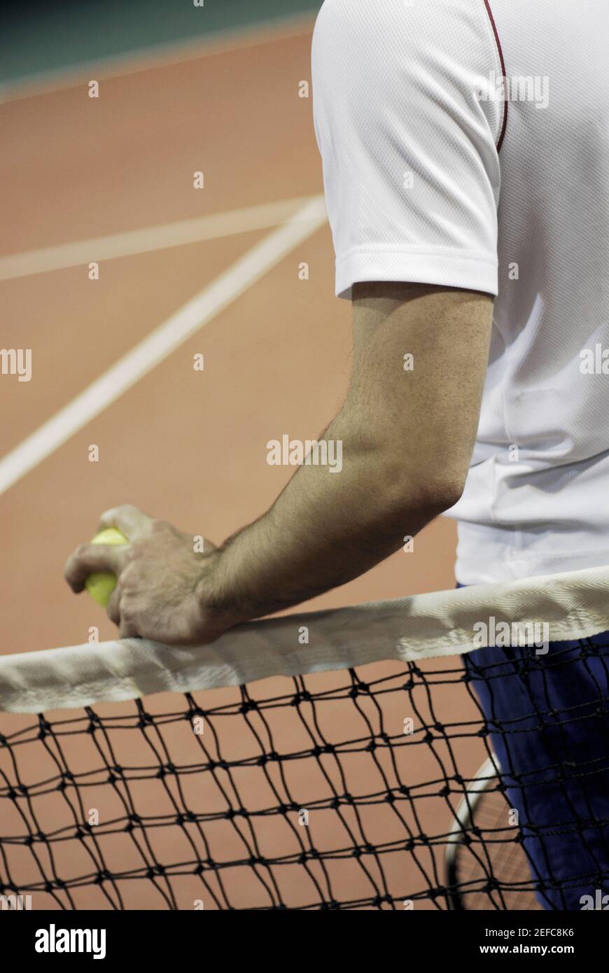 Mittelansicht eines Mannes, der neben einem Tennis steht Netto Stockfoto