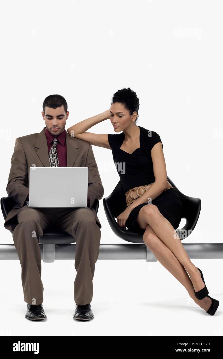 Ein Geschäftsmann mit einem Laptop und eine Geschäftsfrau, die sich auf ihn stützt Schulter Stockfoto