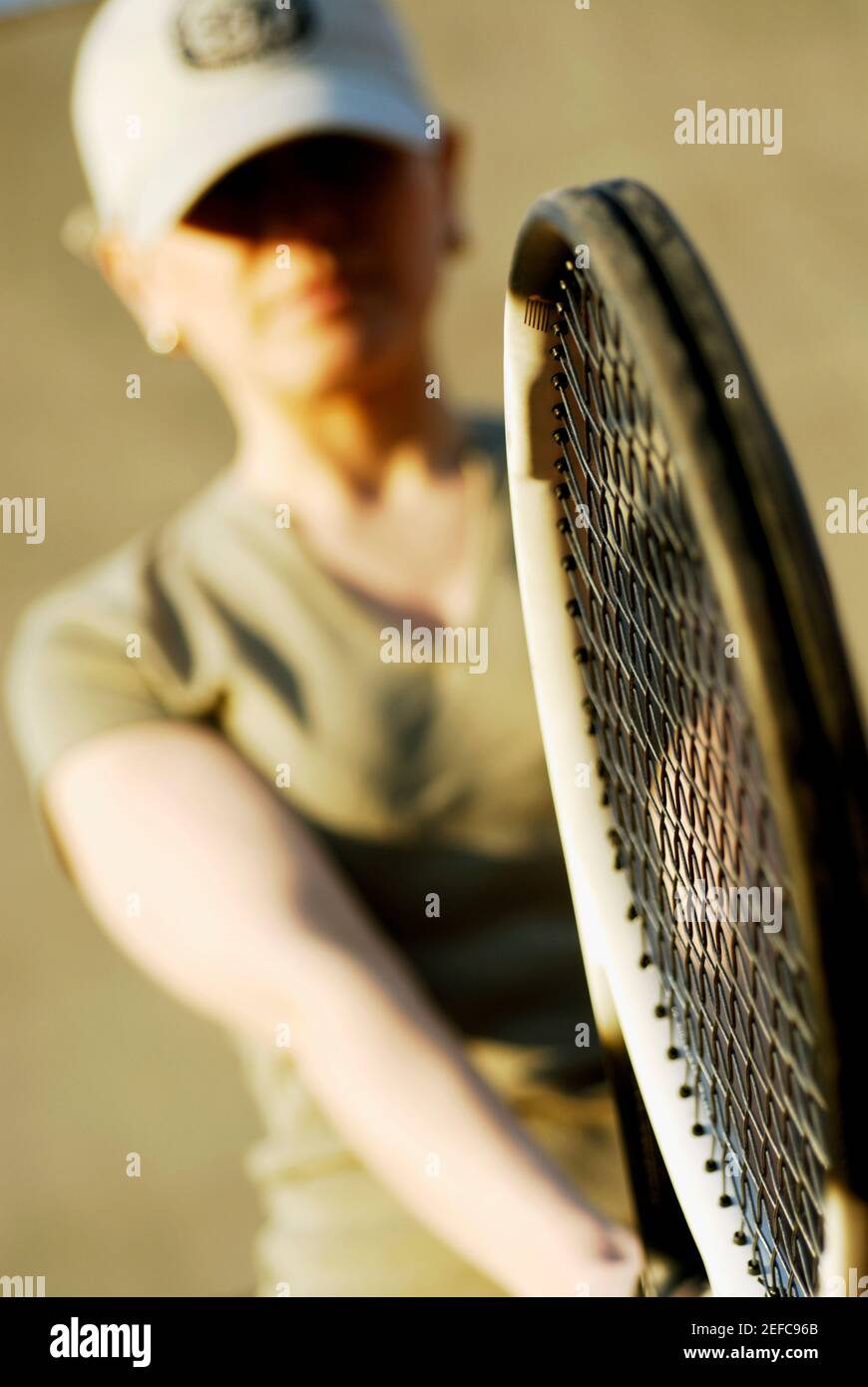 Nahaufnahme einer Frau mit mittlerem Erwachsenen, die einen Tennisschläger hält Stockfoto