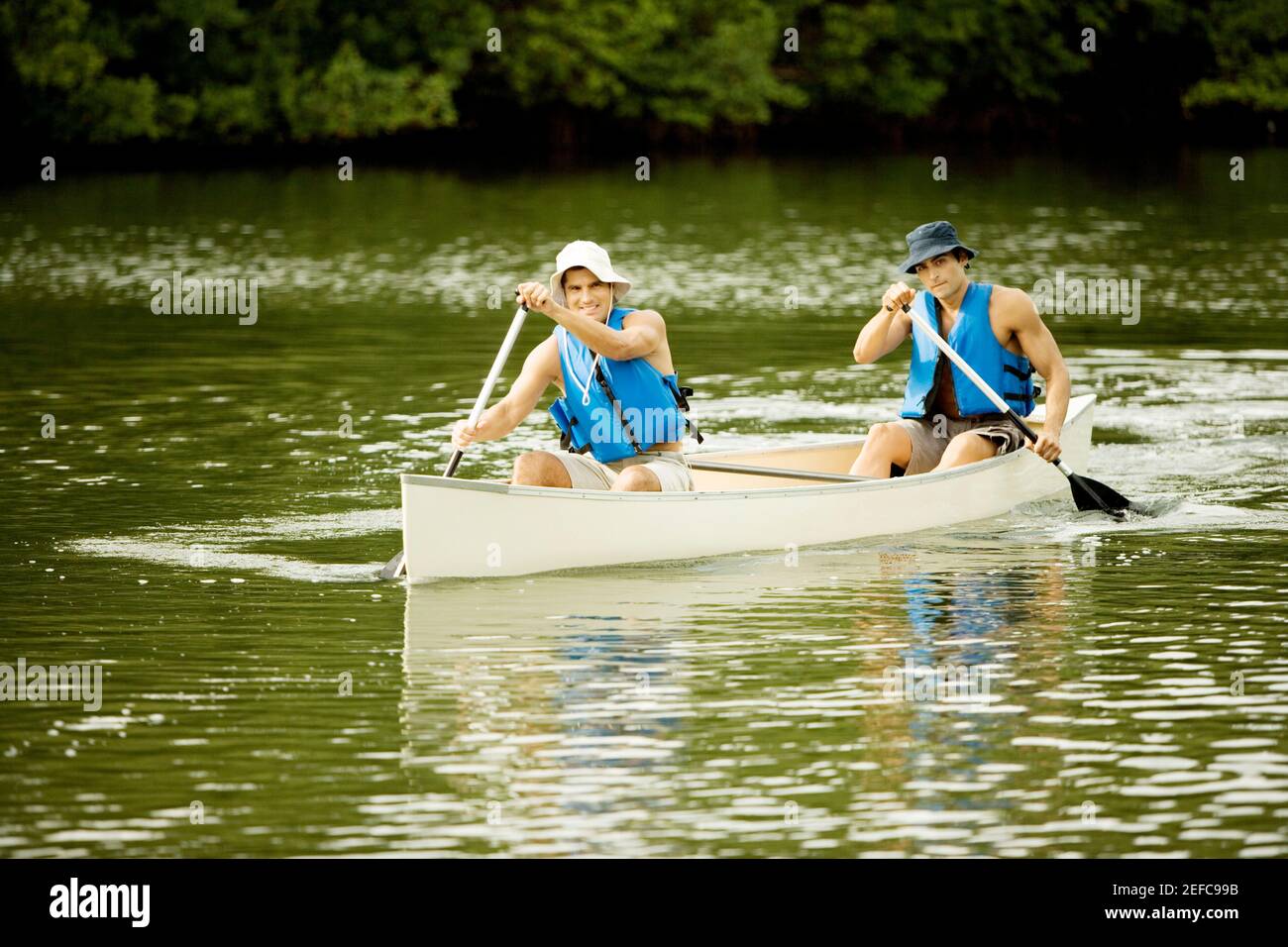 Zwei Männer mit mittlerem Erwachsenenalter, die in einem See Boot fahren Stockfoto
