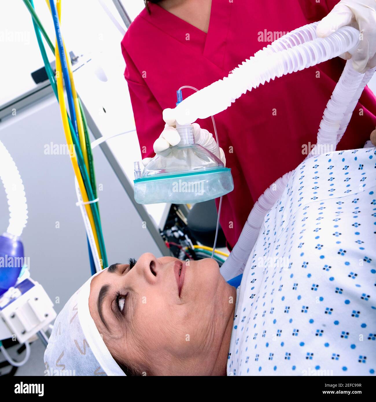 Weibliche Chirurgen setzen eine Sauerstoffmaske auf eine weibliche patientÅ½s Gesicht Stockfoto