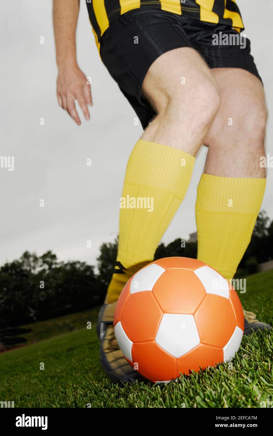 Niedrige Schnittansicht eines Fußballspielers mit einem Fußball spielen Stockfoto