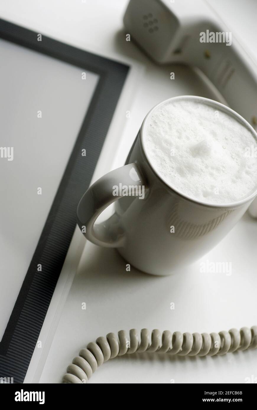 High-Angle-Ansicht einer Tasse Kaffee mit einem Telefonhörer Stockfoto