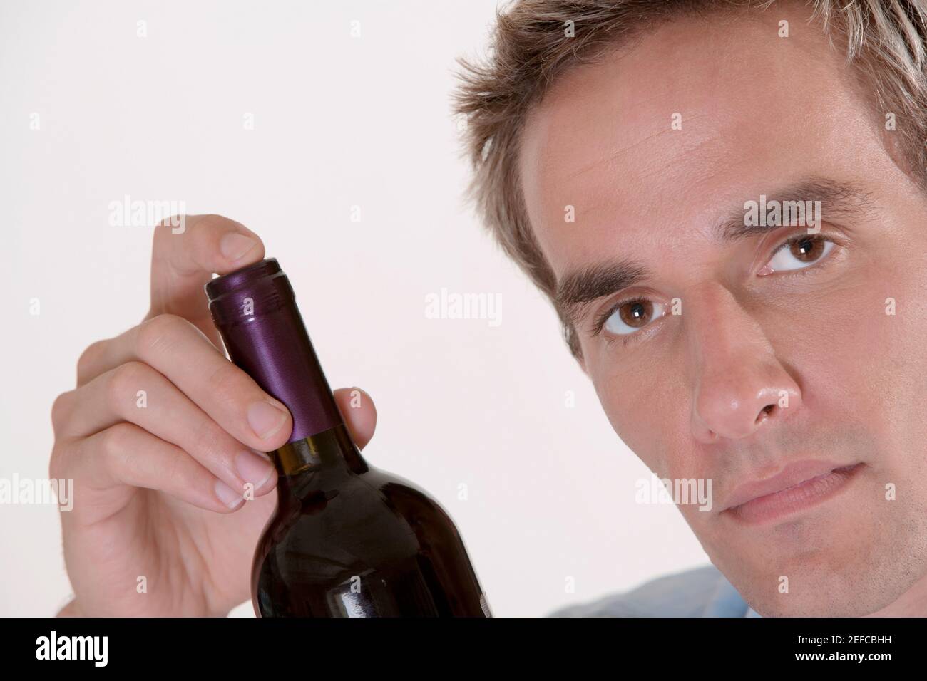 Porträt eines mittleren Erwachsenen Mann hält eine Flasche Rotwein Stockfoto