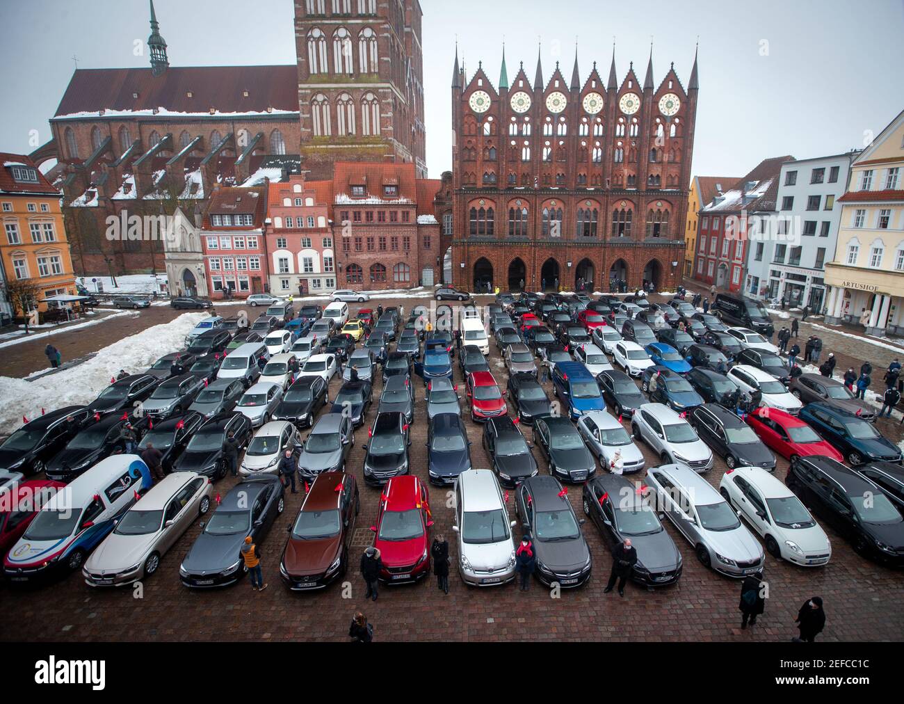 Stralsund, Deutschland. Februar 2021, 17th. Schiffsbauer stehen mit ihren Privatwagen auf dem Marktplatz vor dem Rathaus und demonstrieren für den Erhalt von Arbeitsplätzen auf der MV-Werft. Mehr als ein Drittel der rund 3.000 Arbeitsplätze bei den MV-Werften mit Standorten in Wismar, Warnemünde und Stralsund hatte die Werftleitung angekündigt. Der multinationale Genting Hongkong, der 2016 die Werften übernahm, geriet nach der Corona-Pandemie in Schwierigkeiten. Quelle: Jens Büttner/dpa-Zentralbild/dpa/Alamy Live News Stockfoto