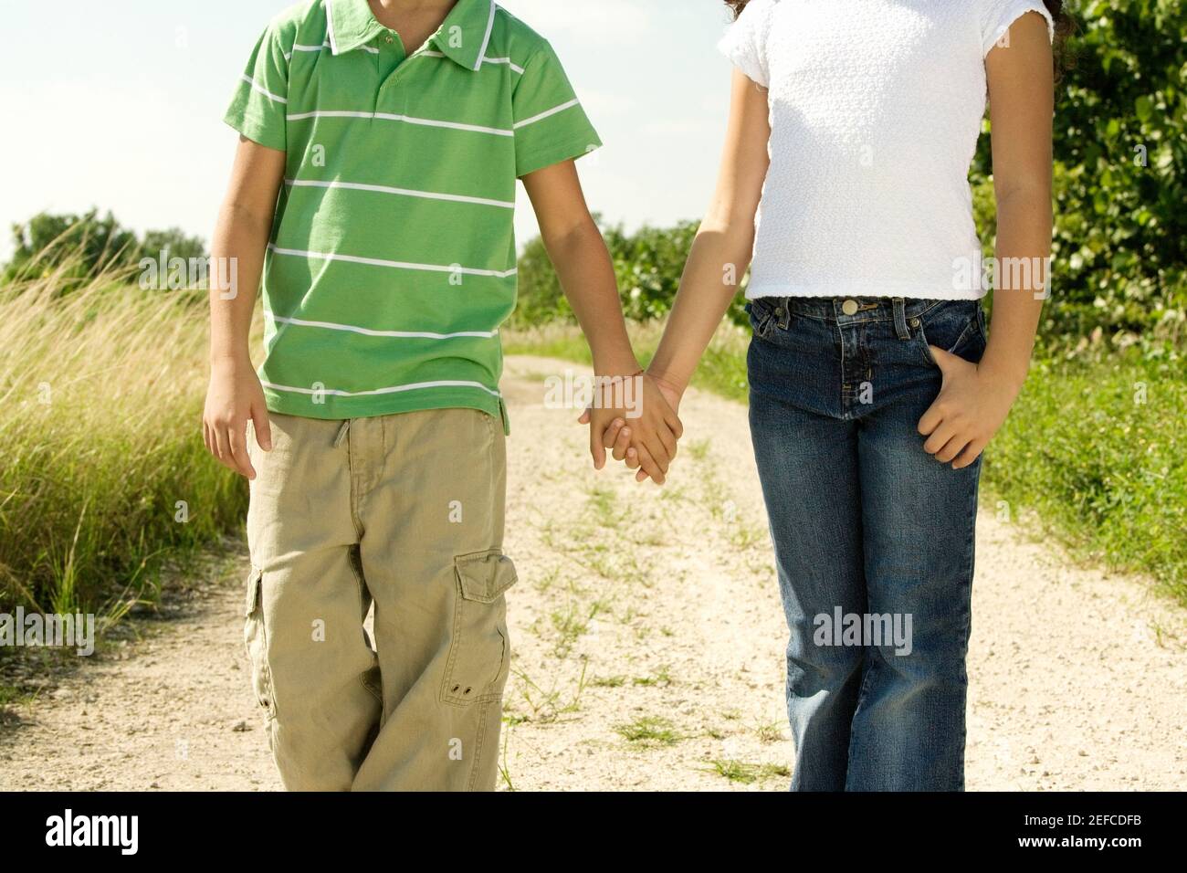 Mittelansicht eines Jungen und eines Mädchens stehen Hände halten Stockfoto