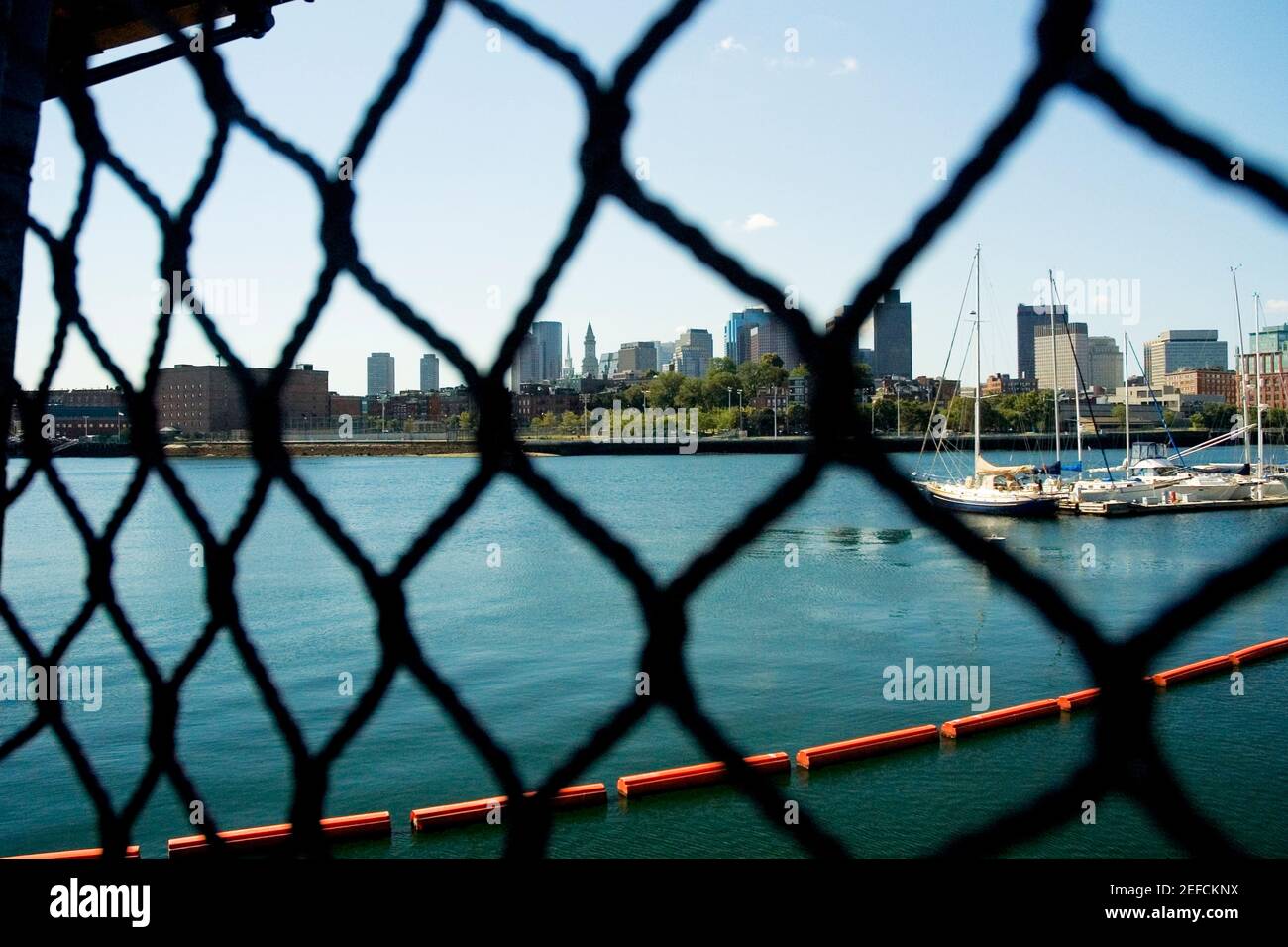Segelboote in einem Fluss durch einen Kettengliedzaun gesehen, Boston, Massachusetts, USA Stockfoto
