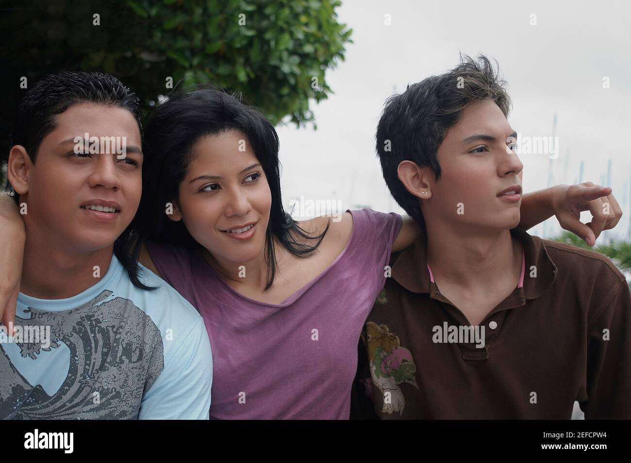 Nahaufnahme einer jungen Frau, die mit zwei jungen Männern sitzt Stockfoto