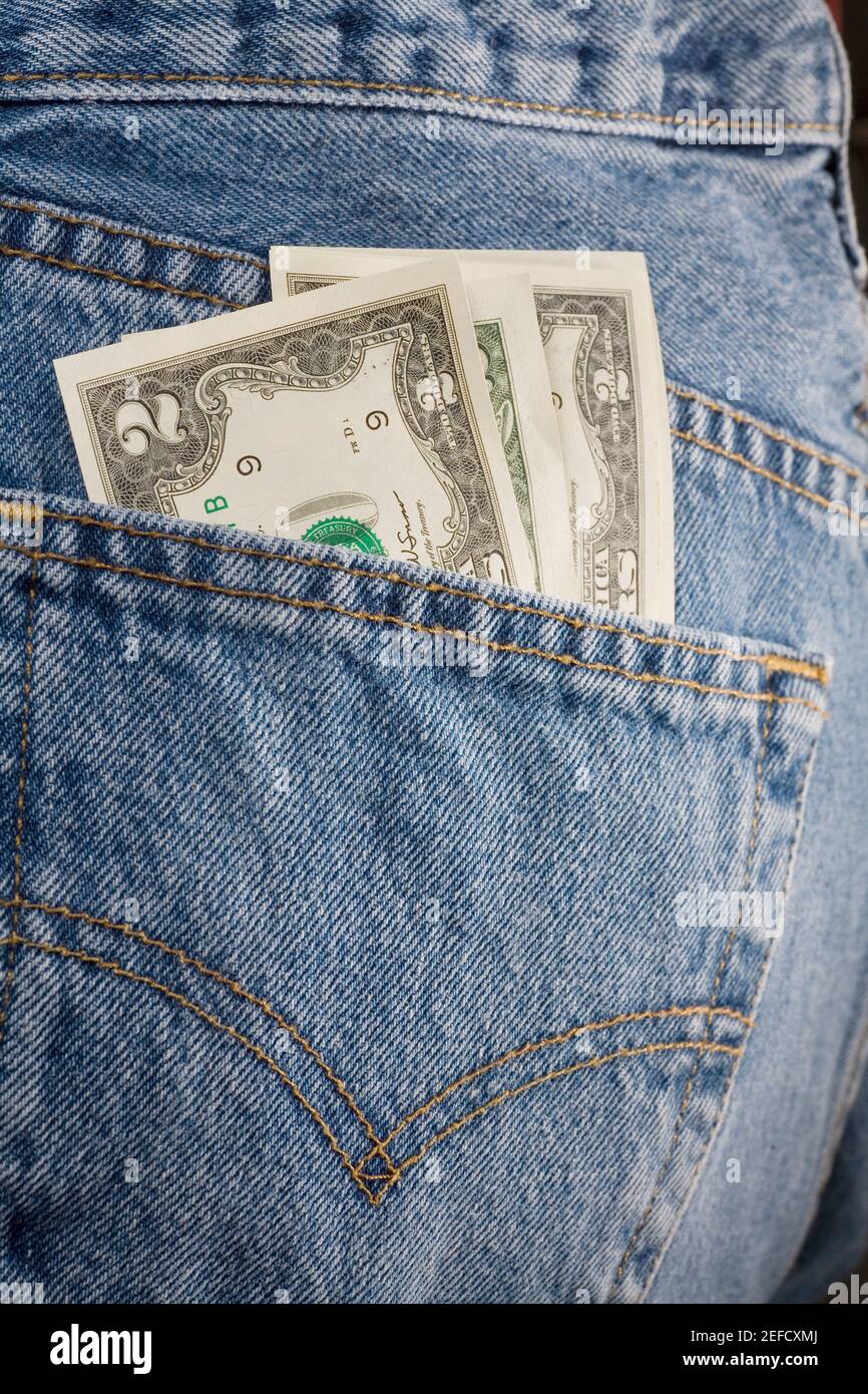 Nahaufnahme von zwei Dollarscheinen in der Tasche eines Jeans Stockfoto