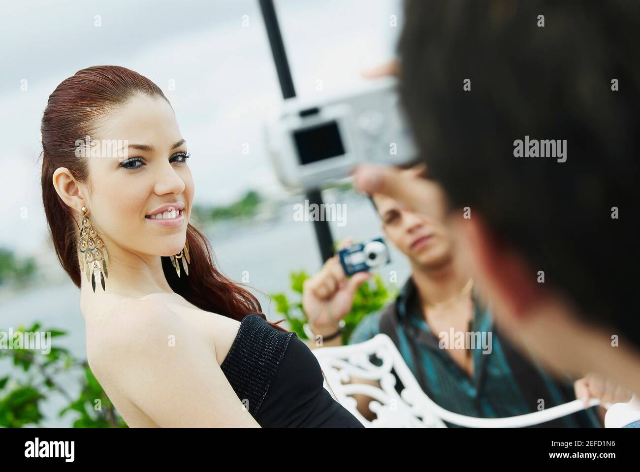 Zwei junge Männer, die ein Bild von einer jungen Frau machen Make-up wird angewendet Stockfoto