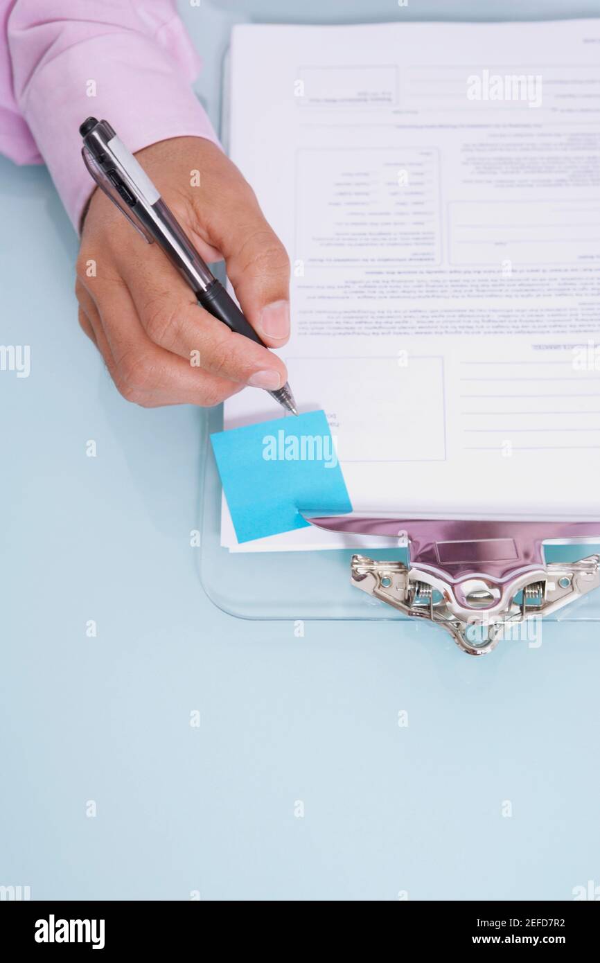 Hochwinkelansicht einer personŽs-Handschrift auf einem Dokument Stockfoto