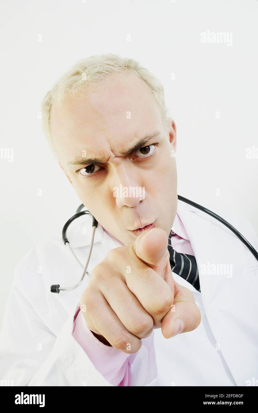 Nahaufnahme eines männlichen Arztes, der nach vorne zeigt und wütend aussieht Stockfoto