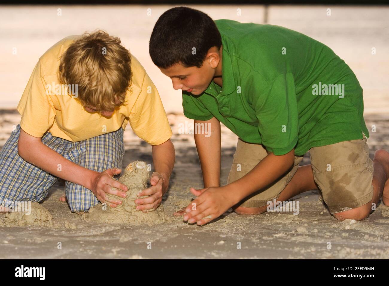 Nahaufnahme von zwei Brüdern, die im Sand spielen Stockfoto