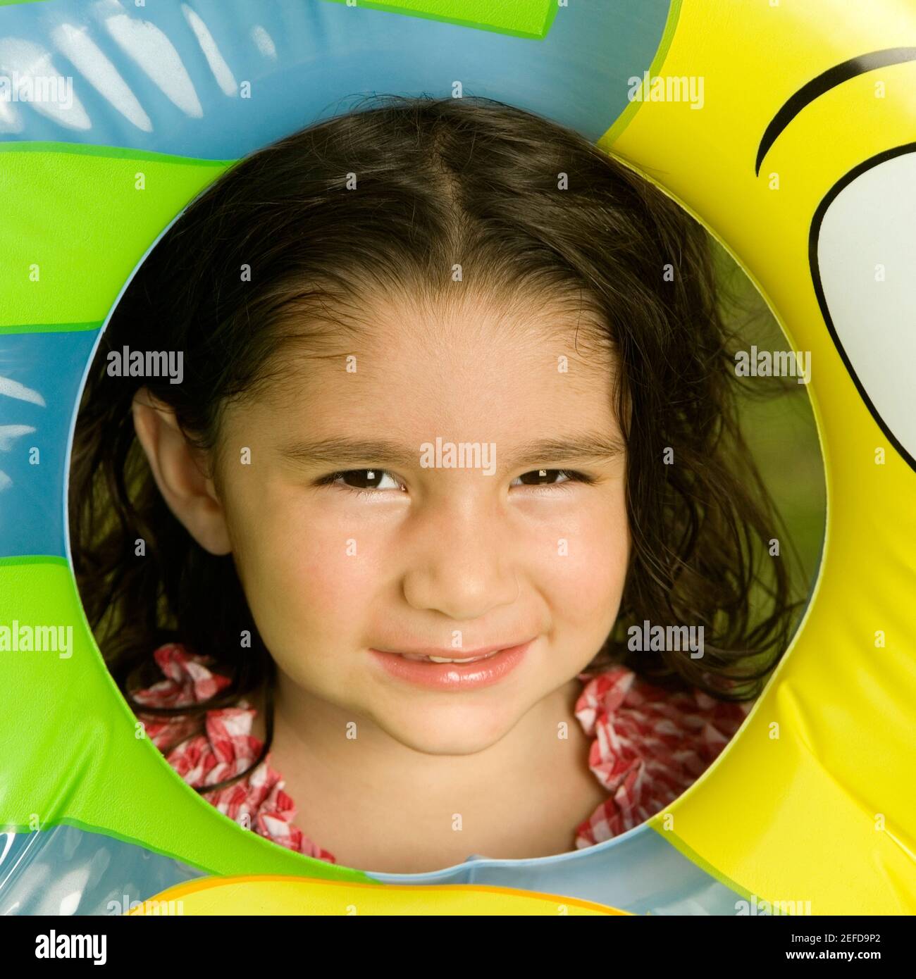 Portrait eines Mädchens, das durch einen aufblasbaren Ring schaut Stockfoto