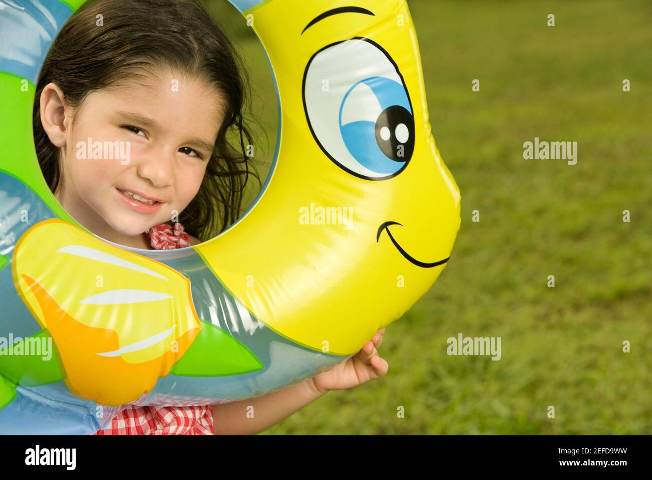 Portrait eines Mädchens, das durch einen aufblasbaren Ring schaut Stockfoto